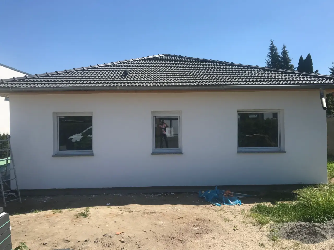 Neubau-Bungalow mit dunkelgrauer Putzfassade und abgesetztem Sockelbereich – Fassadengestaltung Magdeburg