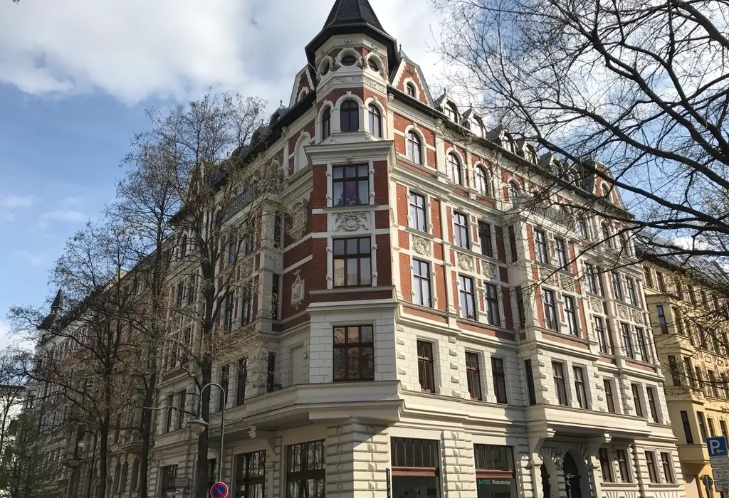Zweistöckiges Wohnhaus mit weiß verputzter Fassade und Gerüst am Hausgiebel – Rekowski-Firmenbanner bei laufender Fassadenrenovierung Magdeburg