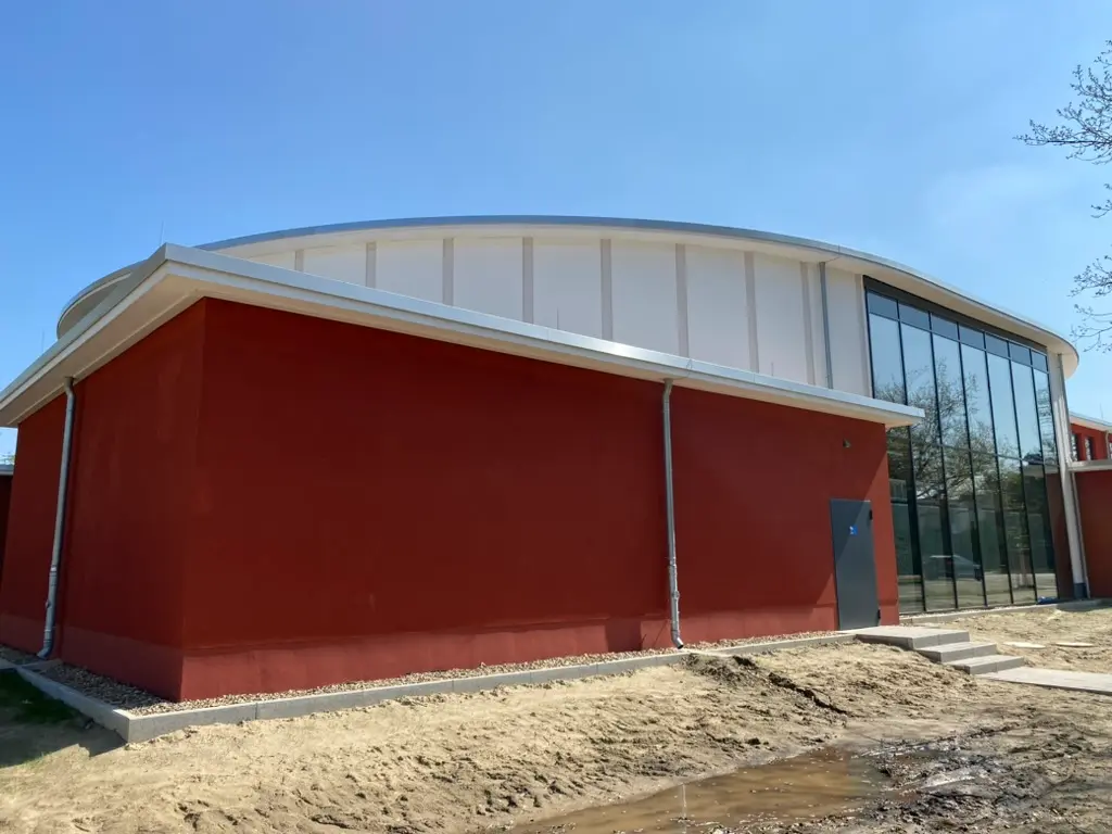 Gewerbliche Fassade in Orange mit Arbeitsbühne beim Außenanstrich – Malerbetrieb Rekowski Magdeburg