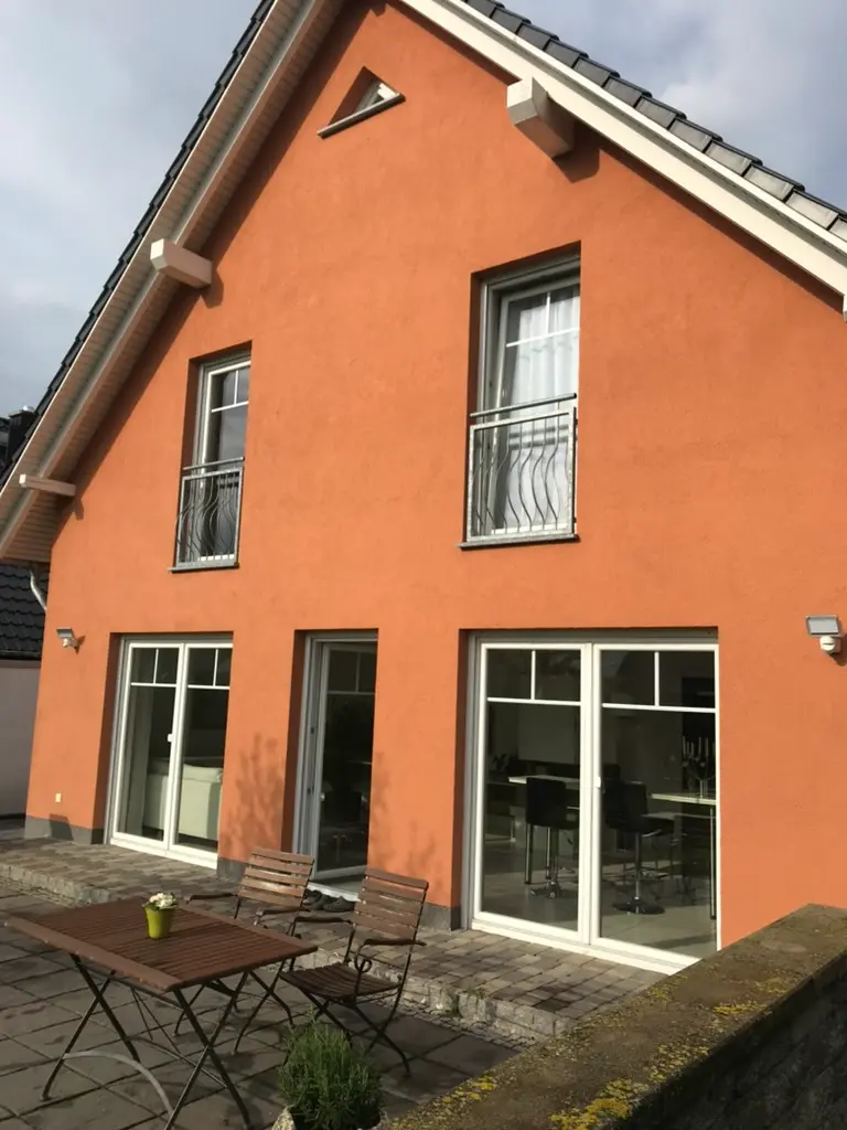 Modernes Einfamilienhaus mit terrakottafarbener Putzfassade nach vollständigem Außenanstrich – Malerbetrieb Rekowski Magdeburg