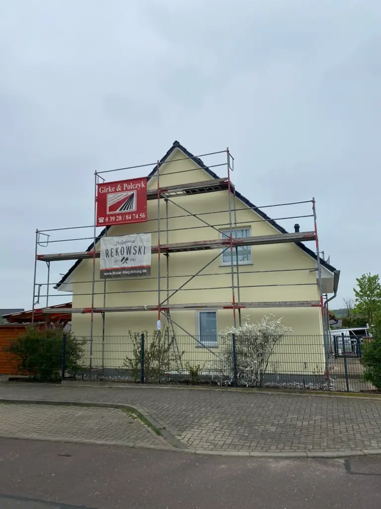 Mehrgeschossiges Wohngebäude mit Gerüst und Malerbetrieb-Rekowski-Beschriftung – Fassadenrenovierung Magdeburg