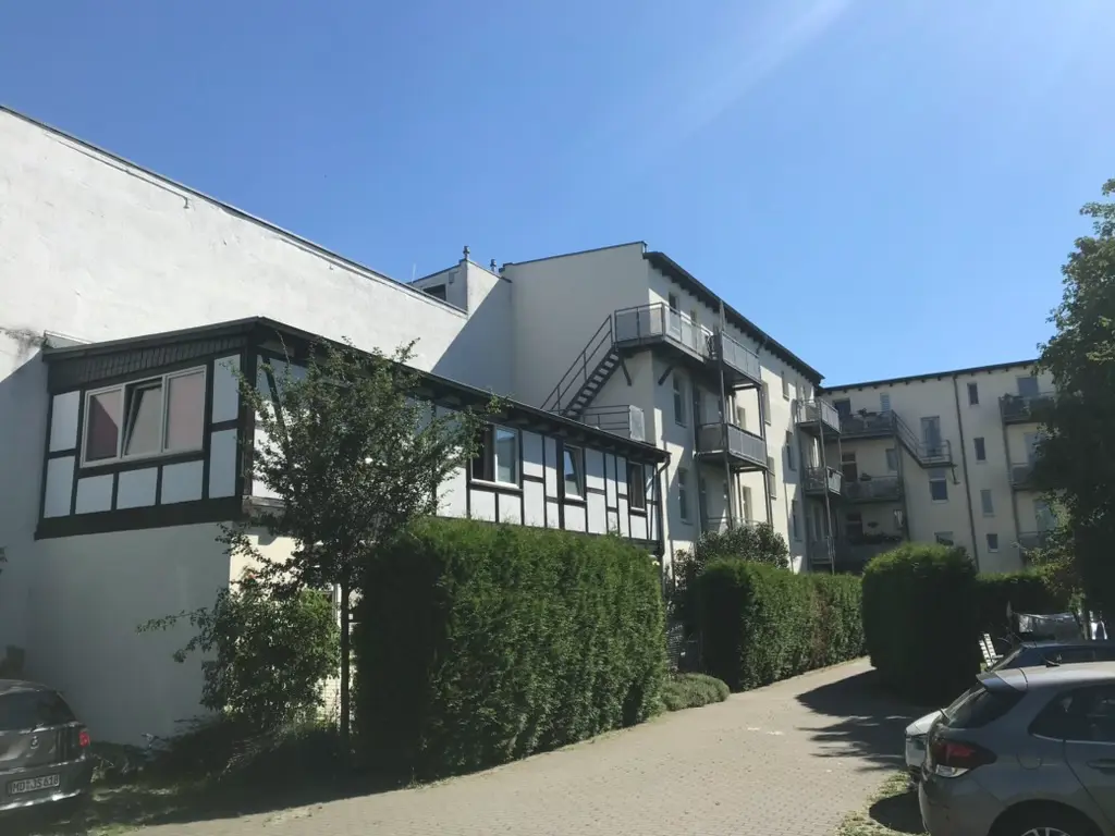 Modernes Gewerbeobjekt mit dunkelroter Putzfassade und großer Glasfront im Rohbau – Fassadengestaltung Magdeburg