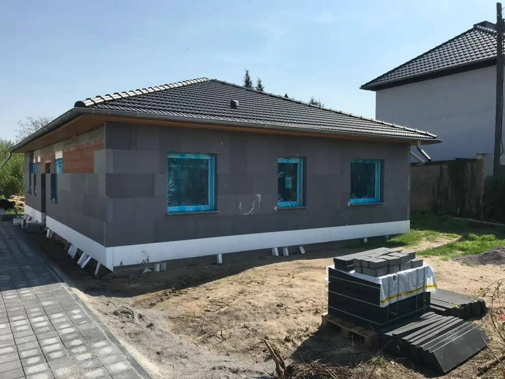 Modernes Gewerbeobjekt mit hellgrauem Außenputz und dunklem Eingangsbereich – Fassadenbeschichtung am Neubau Magdeburg