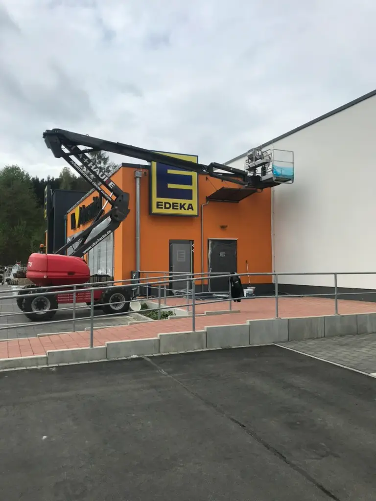 Gewerblicher Außenanstrich mit Hubsteiger – leuchtend orangefarbene Fassade bei gewerblichem Objekt in Magdeburg