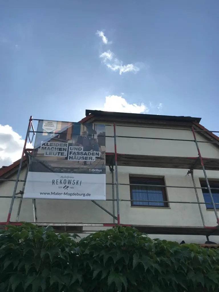 Malerarbeiten in gewerblichem Innenbereich mit weiß gestrichenen Wänden und Arbeitsbühne – Malerbetrieb Rekowski Magdeburg